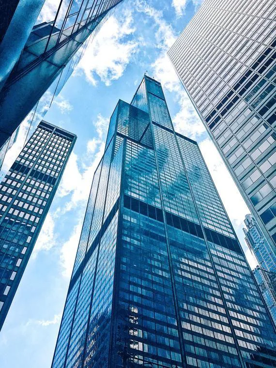 Low-angle view of glass office towers against the sky
